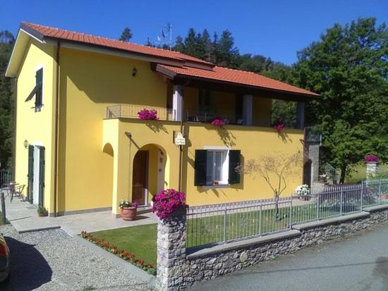 una piccola casa gialla con recinzione e fiori di MammaLisa Casa Vacanze a Colonnella