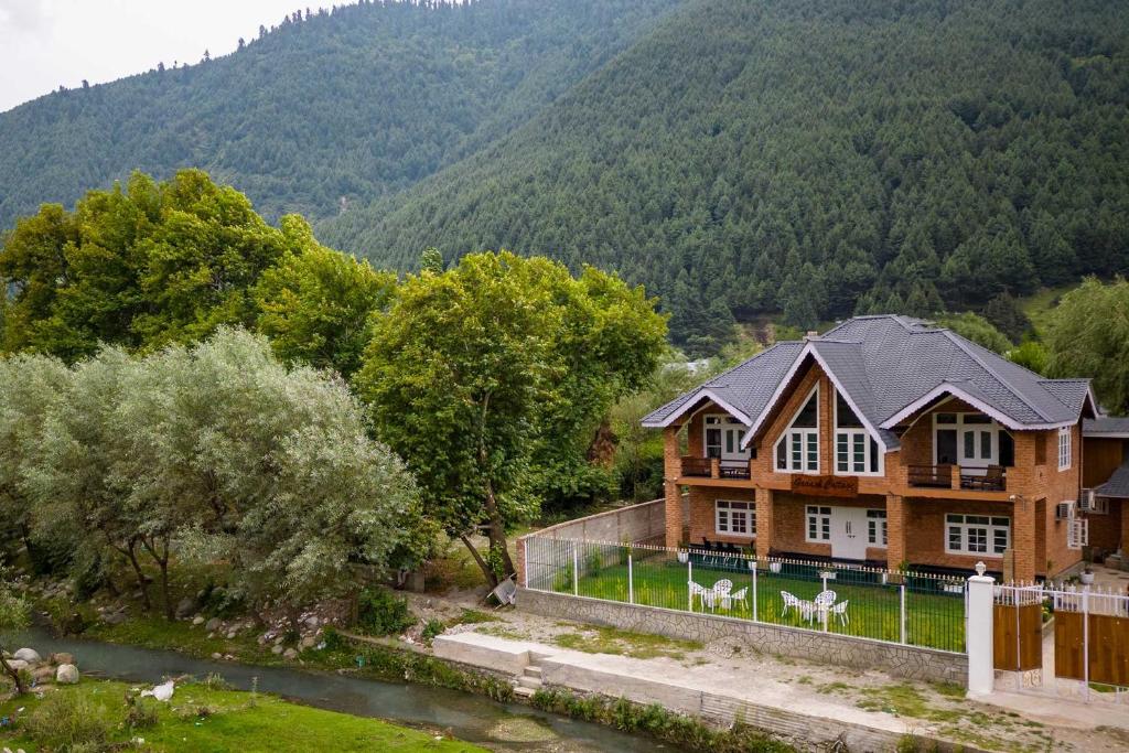 an aerial view of a house in the mountains at StayVista at Gaash Cottage - Pet Friendly Villa with Lawn, Bonfire, WiFi in Sonāmarg
