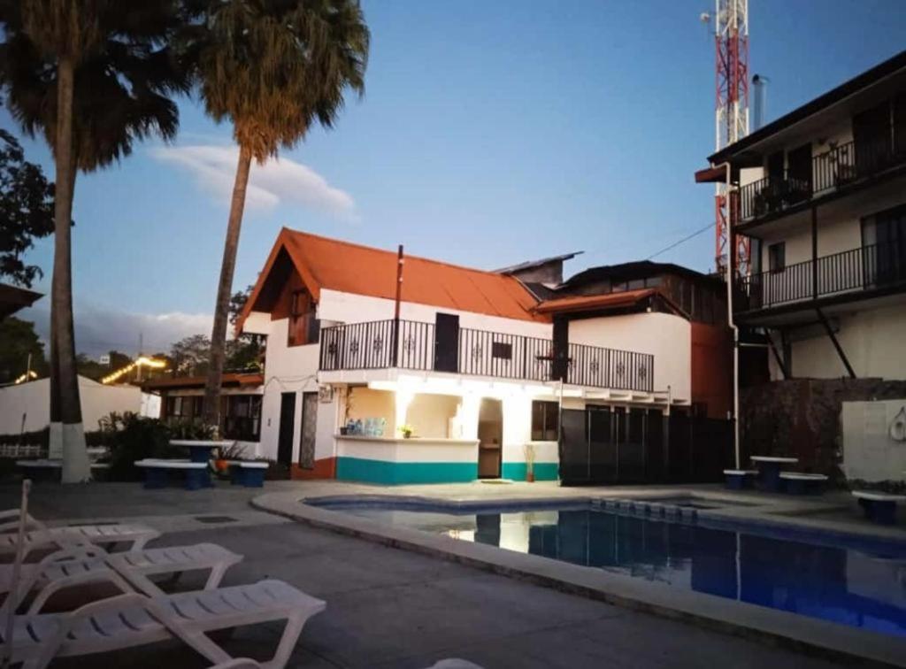 un edificio con piscina y palmeras en Hotel Grecia Costa Rica, en Grecia