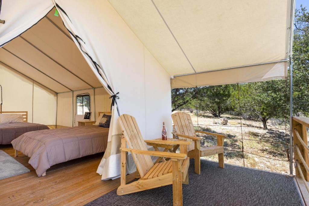 a room with a bed and two chairs in a tent at Stargazer Hill Country Glamping Tent in Boerne
