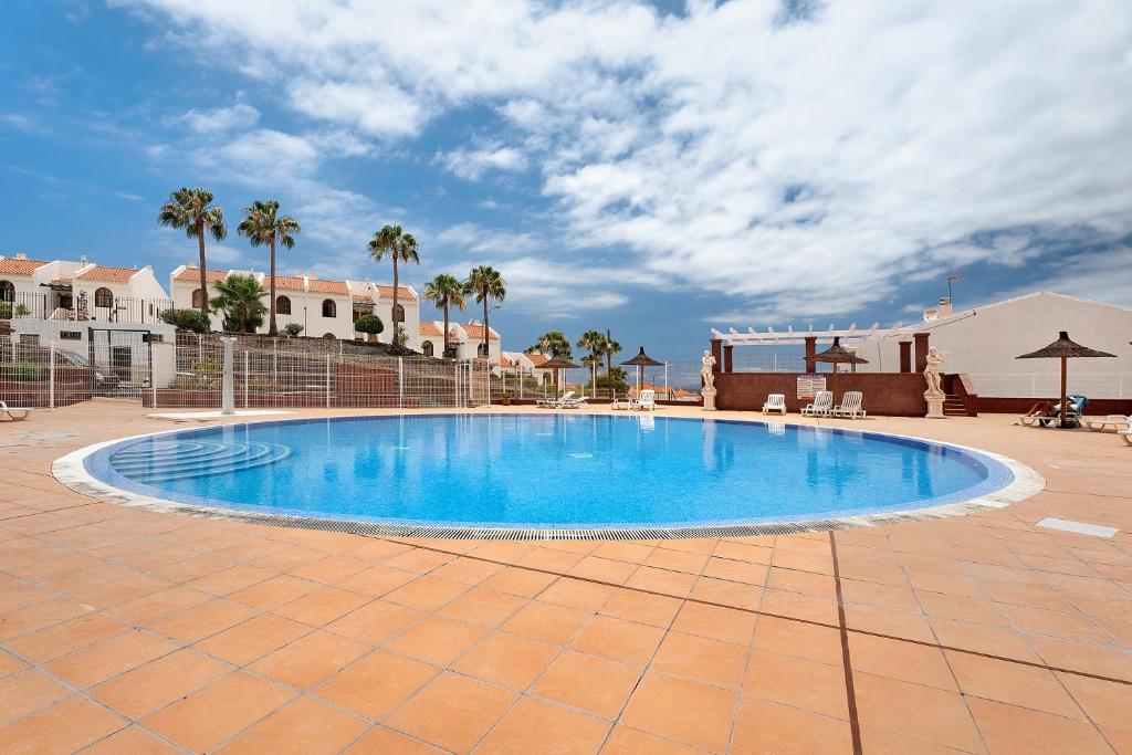 una gran piscina en un patio con palmeras en Torviscas Endless Summer en Adeje