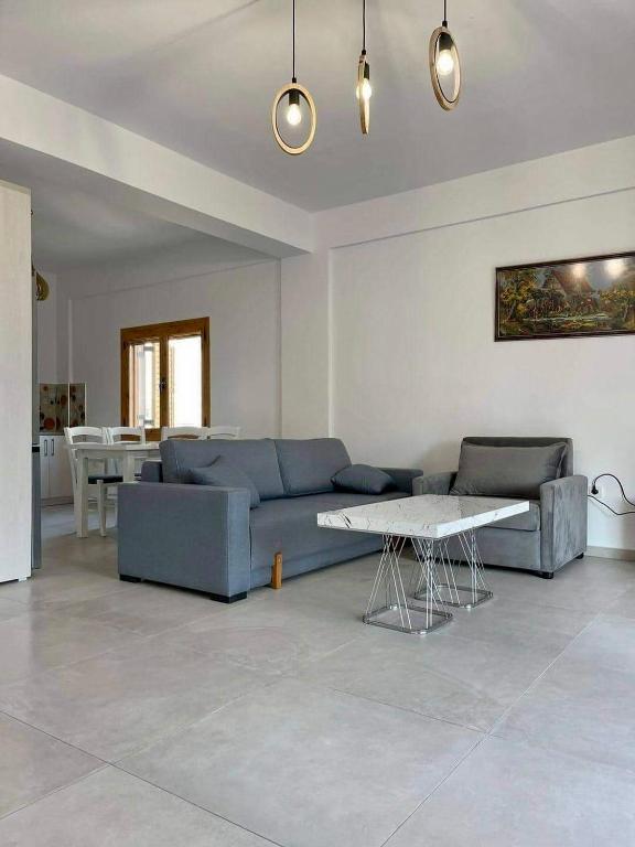 a living room with a blue couch and a table at Dhermi Village Apartments in Dhërmi