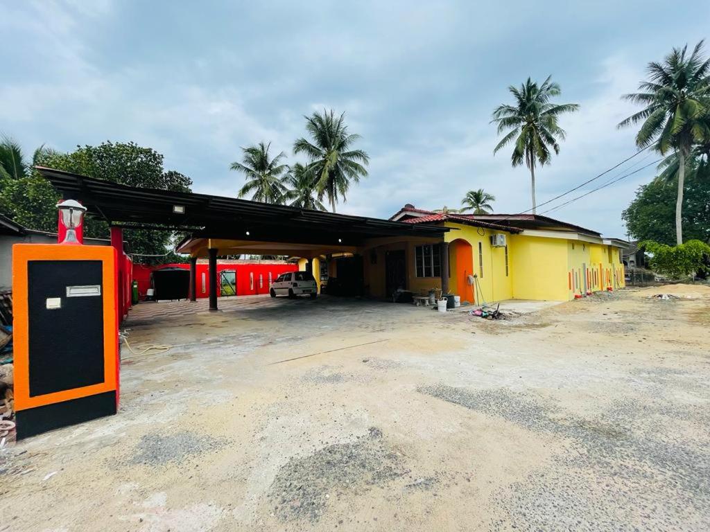 une station-service avec un bâtiment rouge et jaune dans l'établissement Casaria Inn Paka, à Paka