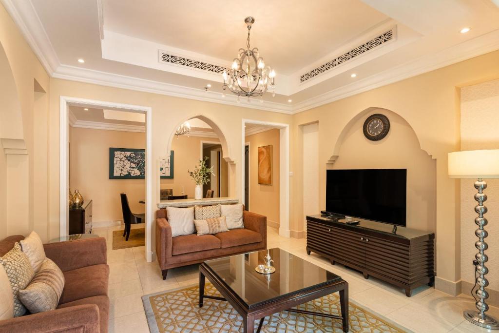 a living room with a couch and a tv at Classic & New - 1BR Apartment in OldTown,Downtown - Allsopp&Allsopp in Dubai