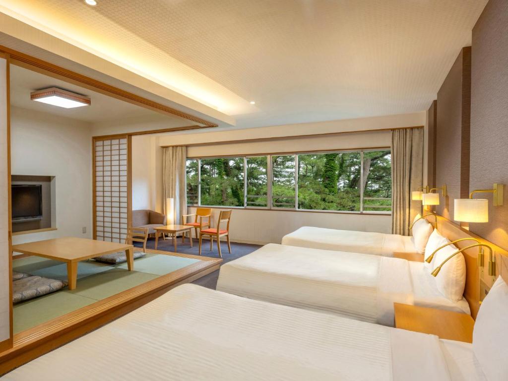 Postel nebo postele na pokoji v ubytování KAMENOI HOTEL Kamogawa