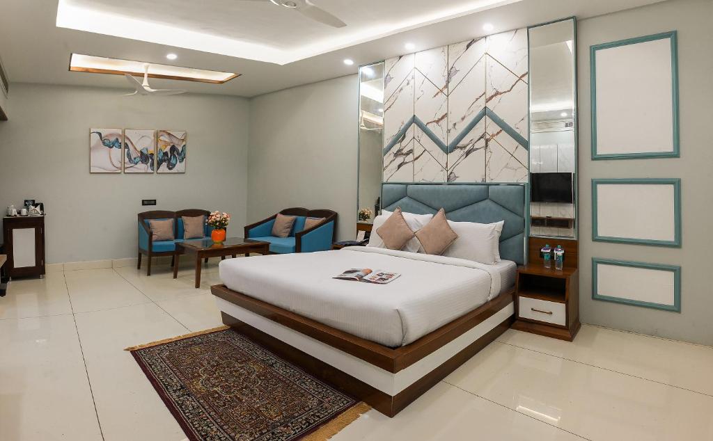 a bedroom with a bed and a living room at Hotel Leela Grande in Karnāl