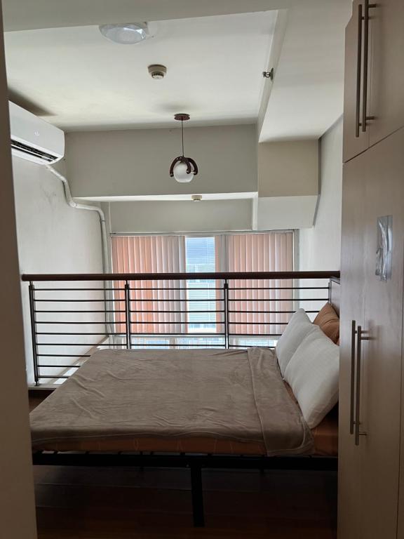 een bed in het midden van een kamer bij eton emerald loft ortigas in Manilla