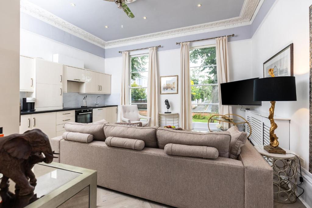 uma sala de estar com um sofá e uma cozinha em 10 Sydenham - By Luxury Apartments em Cheltenham