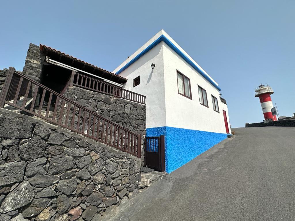 een gebouw met een vuurtoren naast een stenen muur bij Casa Jesus in Fuencaliente de la Palma