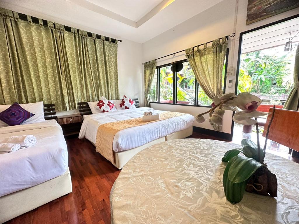 a bedroom with two beds and a large window at Soft Resort Kad Farang Hangdong in Ban Yang Plao
