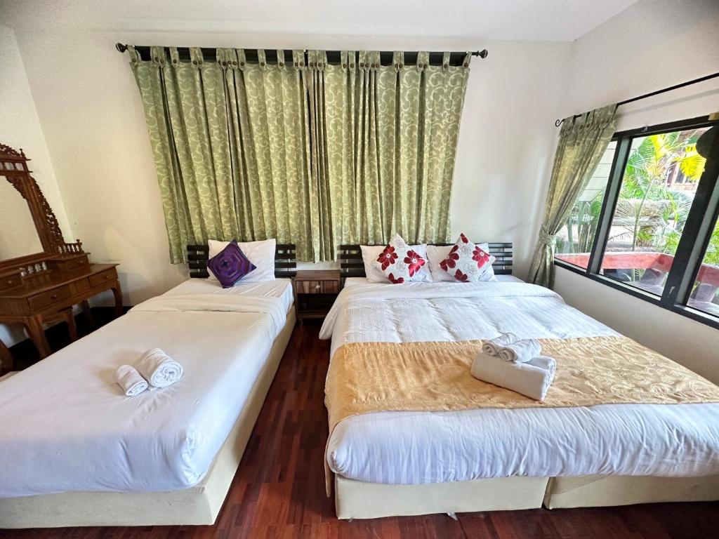 two beds in a room with a window at Soft Resort Kad Farang Hangdong in Ban Yang Plao
