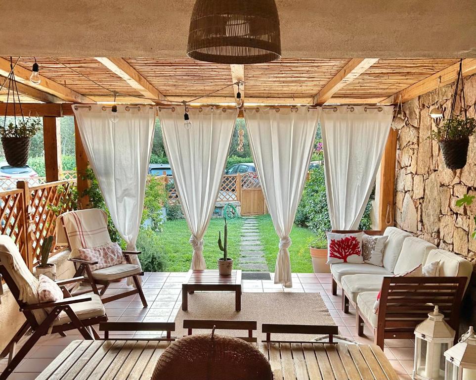 salon z białymi meblami i kamienną ścianą w obiekcie casa sardina palau w mieście Palau
