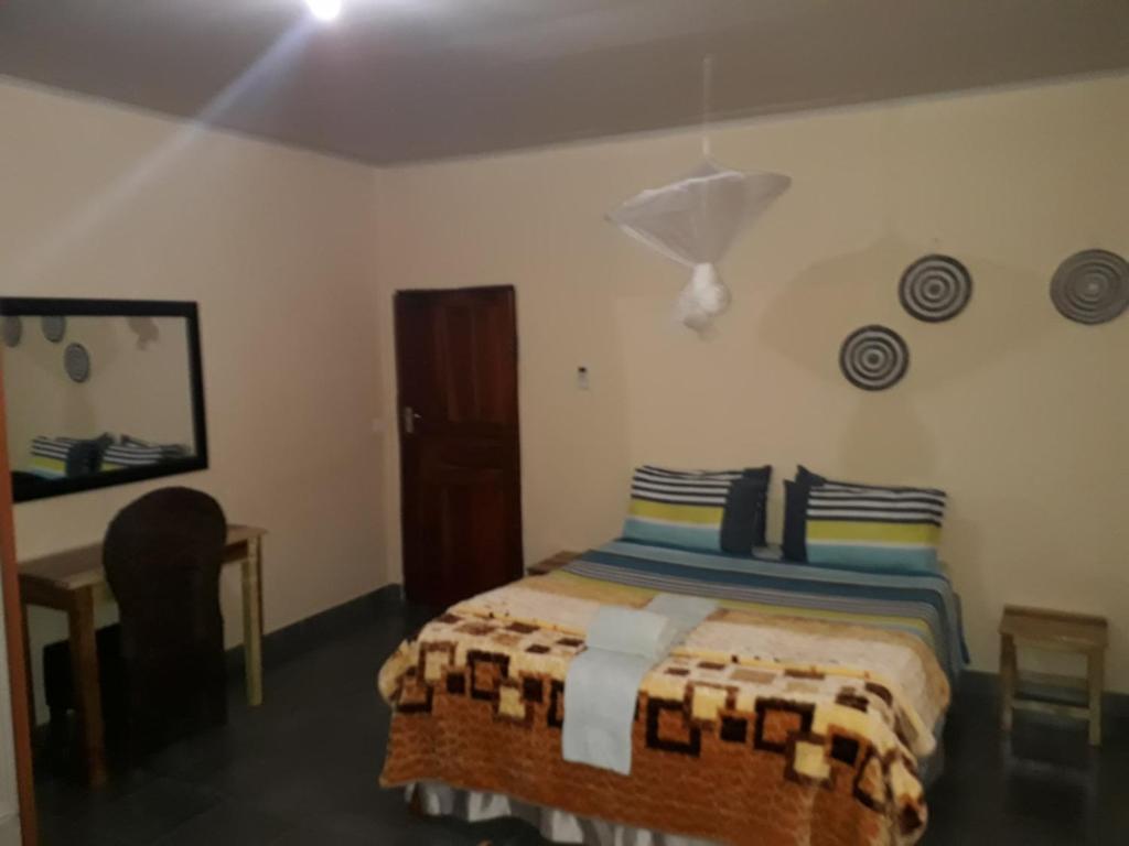 um quarto com uma cama, uma secretária e um espelho em A Nice Homely 2- Bedroom House em Livingstone