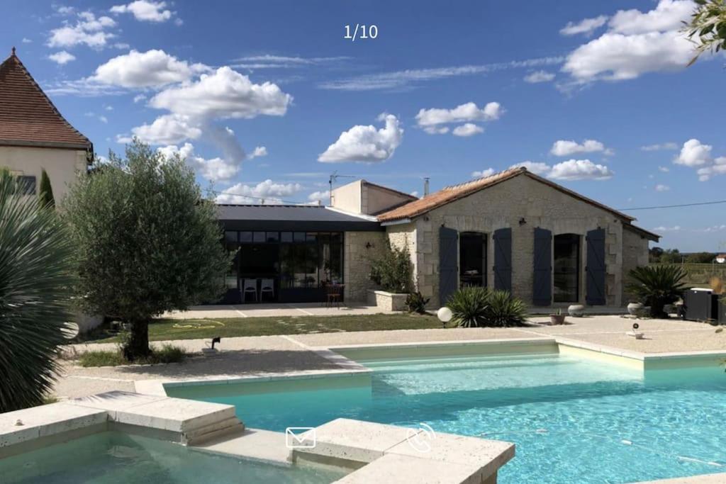 a large swimming pool in front of a house at Demeure charentaise Standing - Grande Piscine - jacuzzi balnéo - Pool house in Barbezieux-Saint-Hilaire