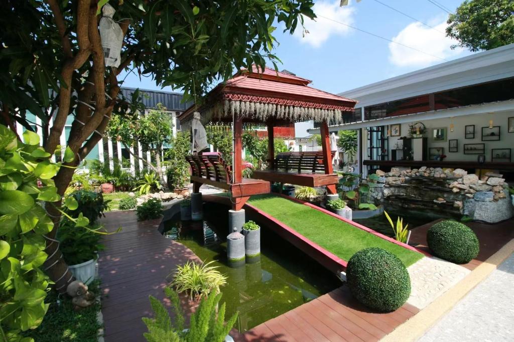 a garden with a gazebo and a pond at Sunny Dala villa in Nong Prue