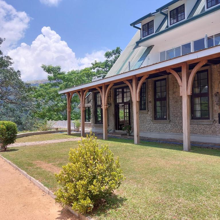 a large house with a porch and a grass yard at VillaEliza in Matale
