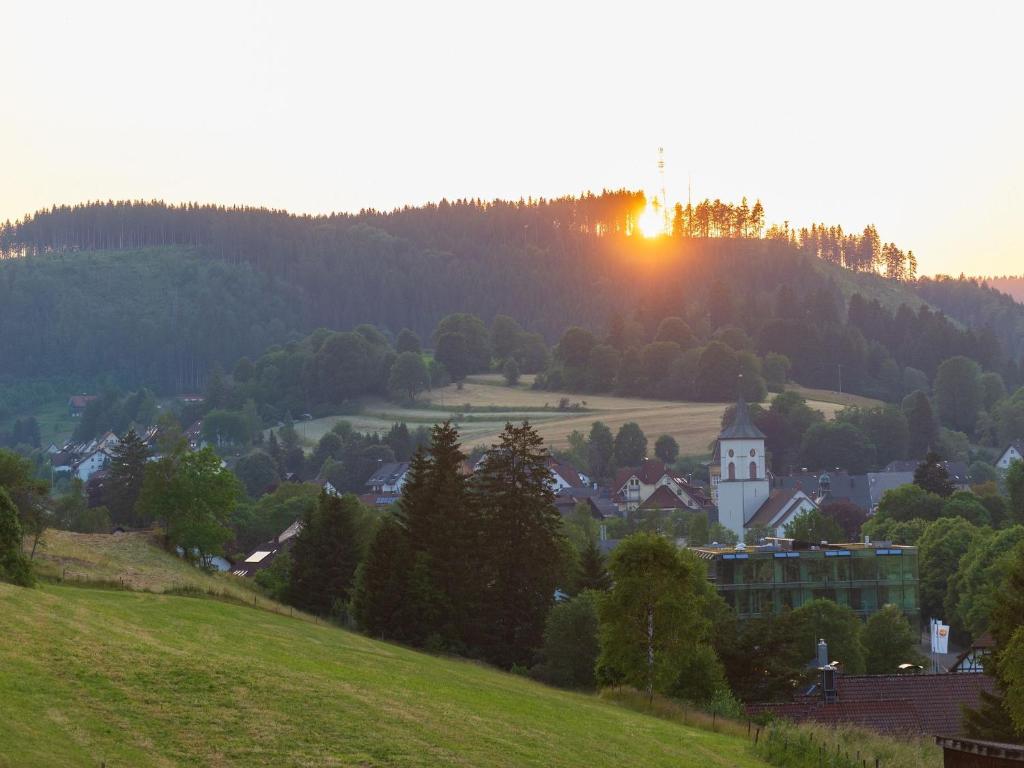 una puesta de sol sobre un pequeño pueblo en una colina en Wälderliebe, en Lenzkirch