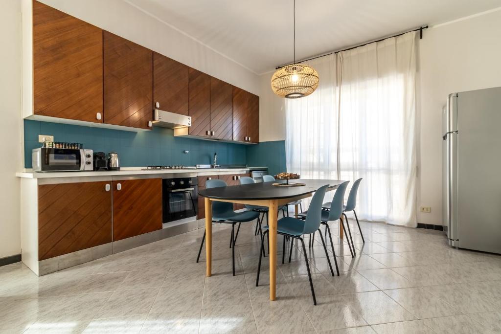 a kitchen with a table and chairs and a refrigerator at A Tutto Tondo Apartment - Lerici in Lerici