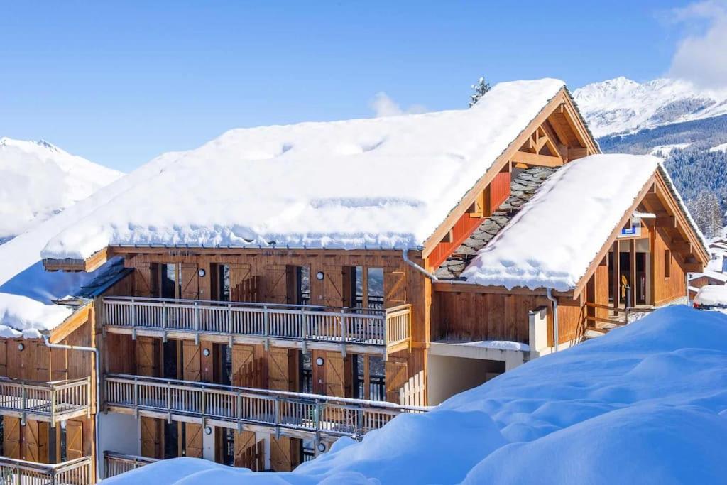 un lodge de ski dans la neige avec des toits enneigés dans l'établissement Appartement les Coches-Monchavin, à La Plagne Tarentaise