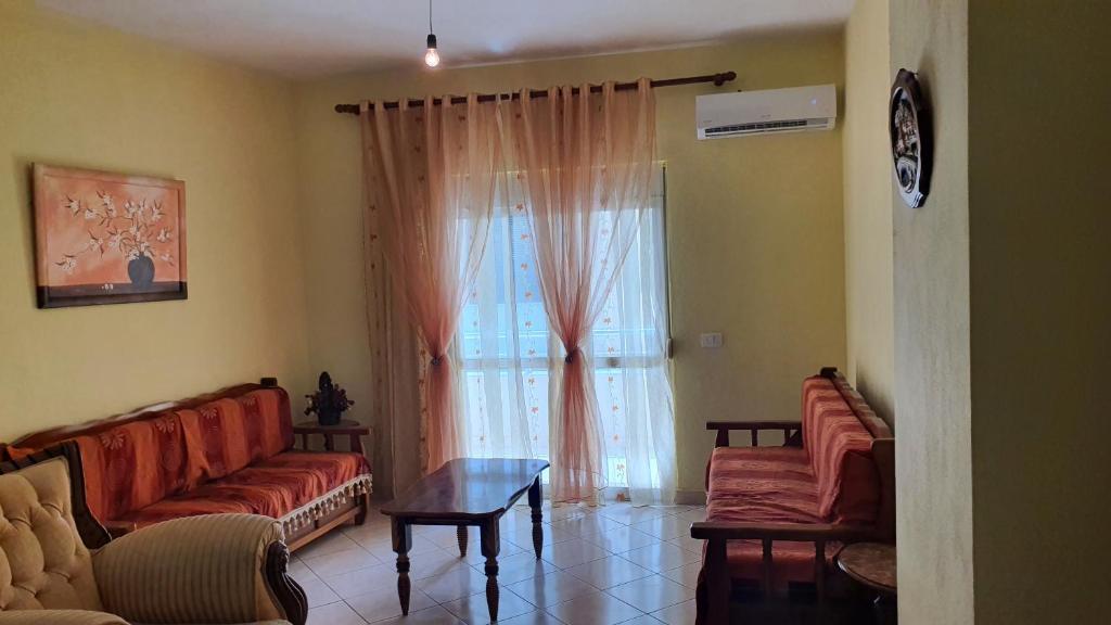 een woonkamer met 2 banken en een raam bij Rent Apartament Bardho in Durrës