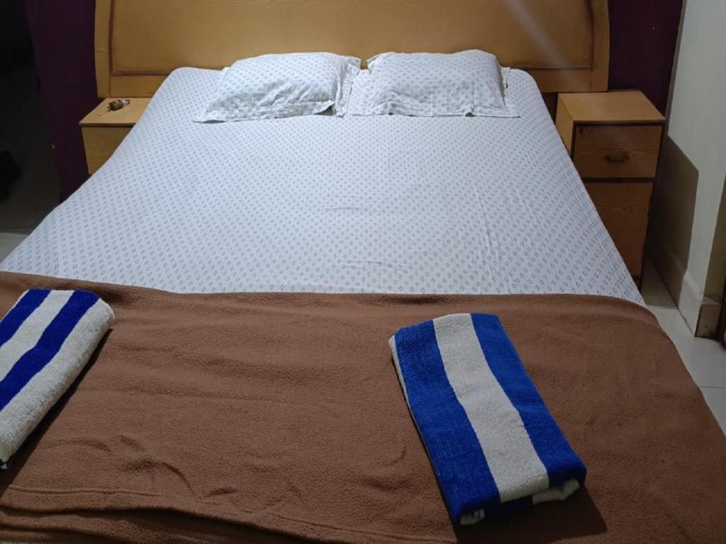 Una cama con toallas de rayas azules y blancas. en Dmello Guest House en Canacona