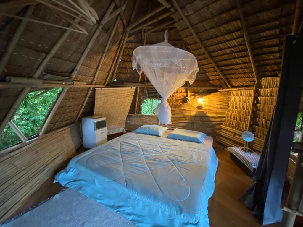 ein Bett im Inneren eines Zeltes in der Unterkunft Royal mountain Hut in Ratchaburi