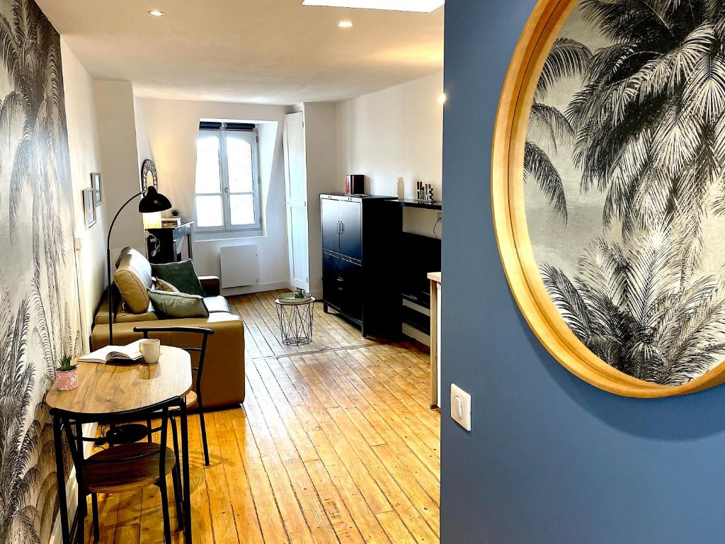 ein Wohnzimmer mit einem Tisch und einem Spiegel in der Unterkunft Studio de charme sous les toits #6 in Dreux