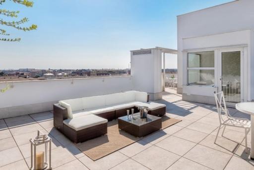 uma sala de estar com um sofá e uma mesa no telhado em panoramic luxury penthouse 6 people em Milão