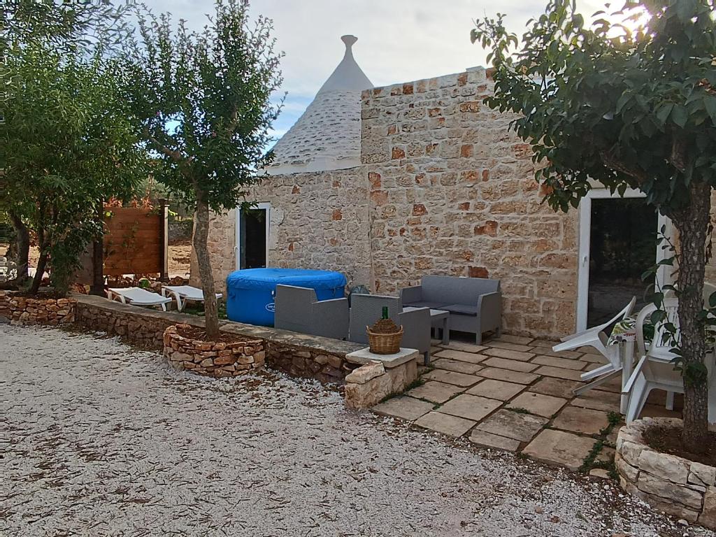 un patio con sedie e tavoli e un edificio di Trullo Victory a Martina Franca