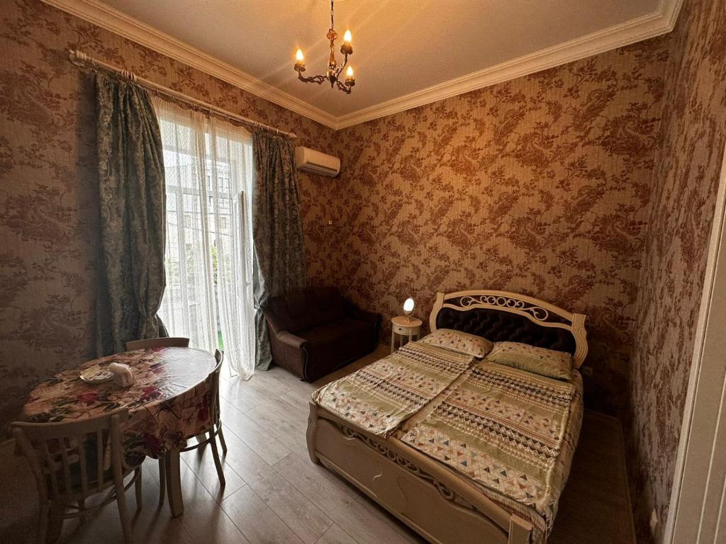 een slaapkamer met een bed, een tafel en een stoel bij STEPROOMS in Tbilisi City