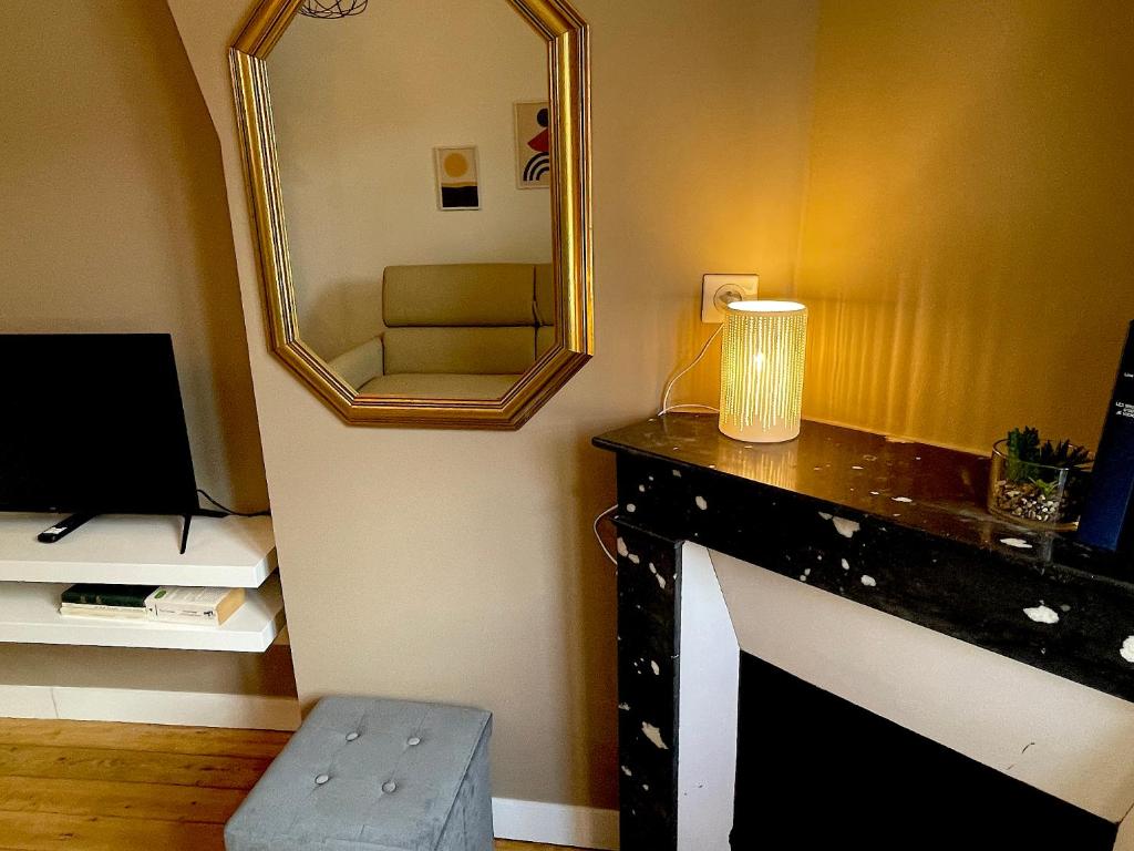um quarto com um espelho e uma secretária com uma cadeira em Vue Royale, Cœur Ville, lumineux #5 em Dreux