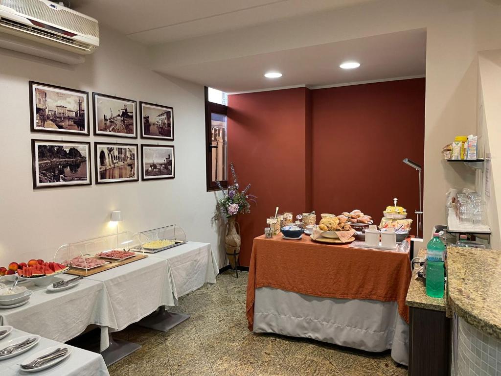 un restaurante con dos mesas con comida. en Albergo Tecla en Lazise