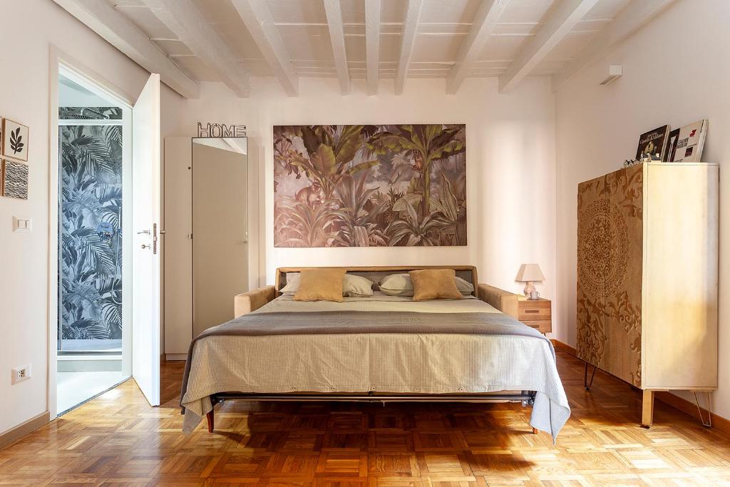 ein Schlafzimmer mit einem Bett und einem Wandgemälde in der Unterkunft Appartamento Porta Ticinese - Navigli in Mailand