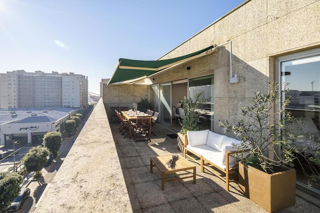 patio z kanapą i stołem w budynku w obiekcie Ocean Front 4-bed Luxury w/ Terrace & Parking w mieście Matosinhos