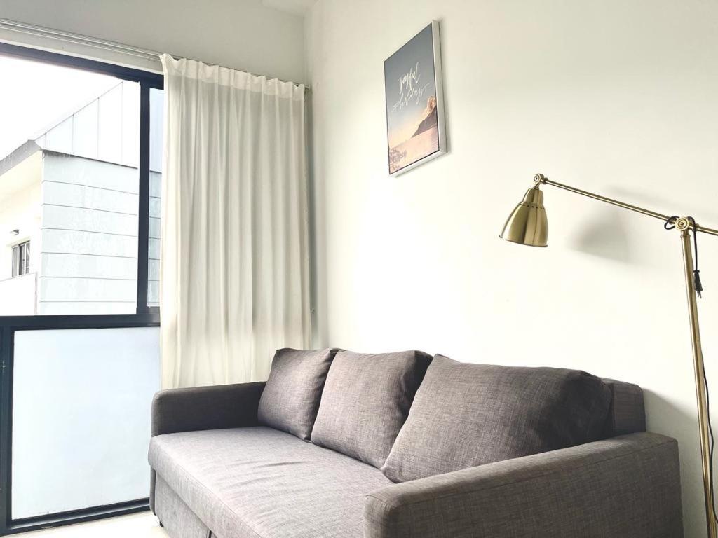 a living room with a couch and a window at 2 BR with city view near Subway in central in Singapore