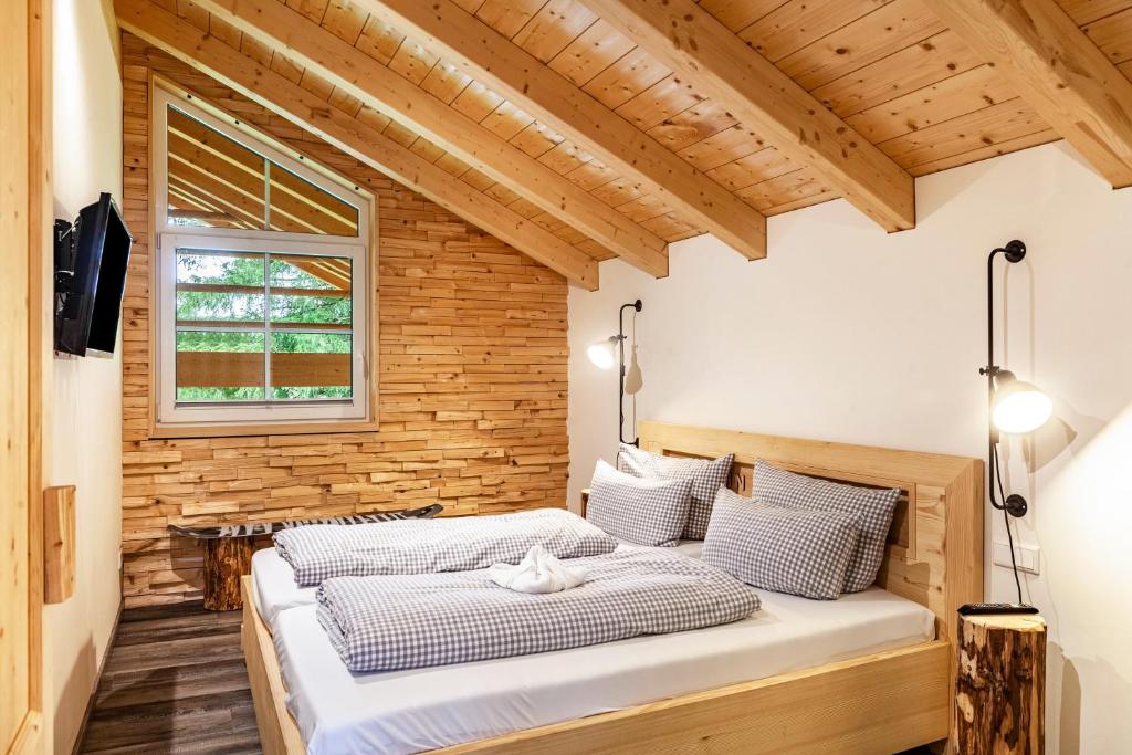 two beds in a room with a wooden wall at Chalet Rauschn 1 in Farchant