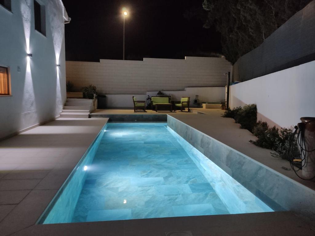 a swimming pool in the middle of a patio at night at Apto. El Pozo de las Nieves con piscina in Cobisa