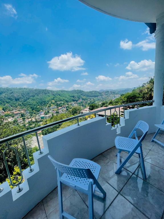 a balcony with chairs and a view of the city at Rusty Bunk Villa in Kandy