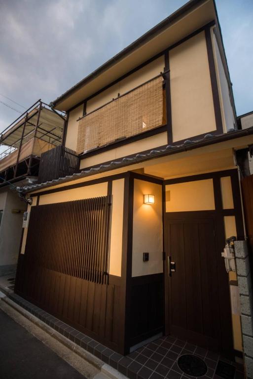 a house with a brown door and a fence at 喜楽・里桜 in Kyoto