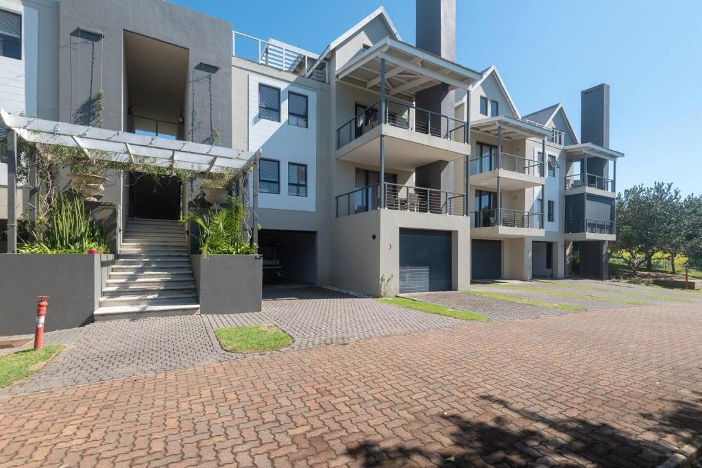 a large apartment building with a brick driveway at Refined 3 Bedroom Apartment Princes Grant in Blythedale