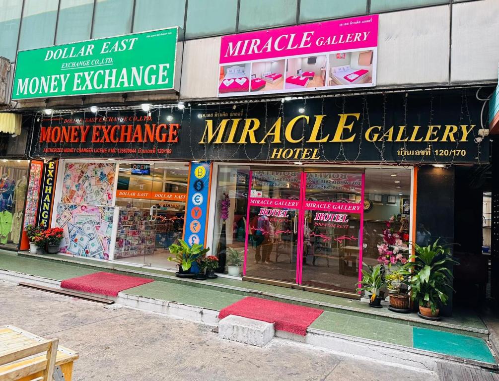 Makkasan的住宿－Miracle Gallery Hotel，建筑前面的商店,有很多标志