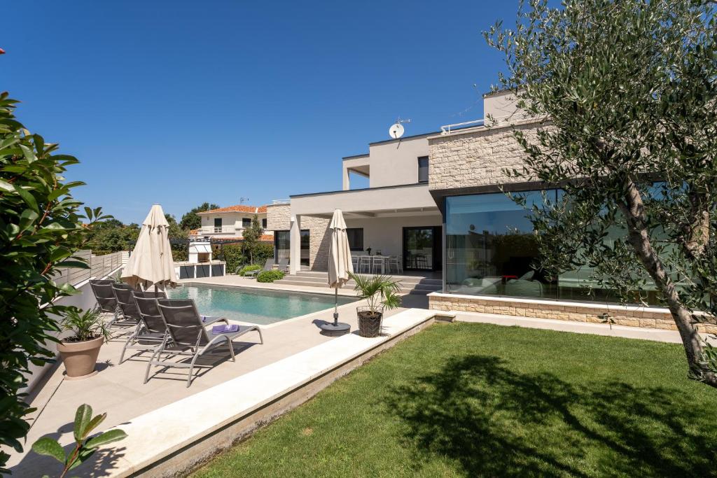 ein Haus mit Pool und Rasen in der Unterkunft Villa Anni in Poreč