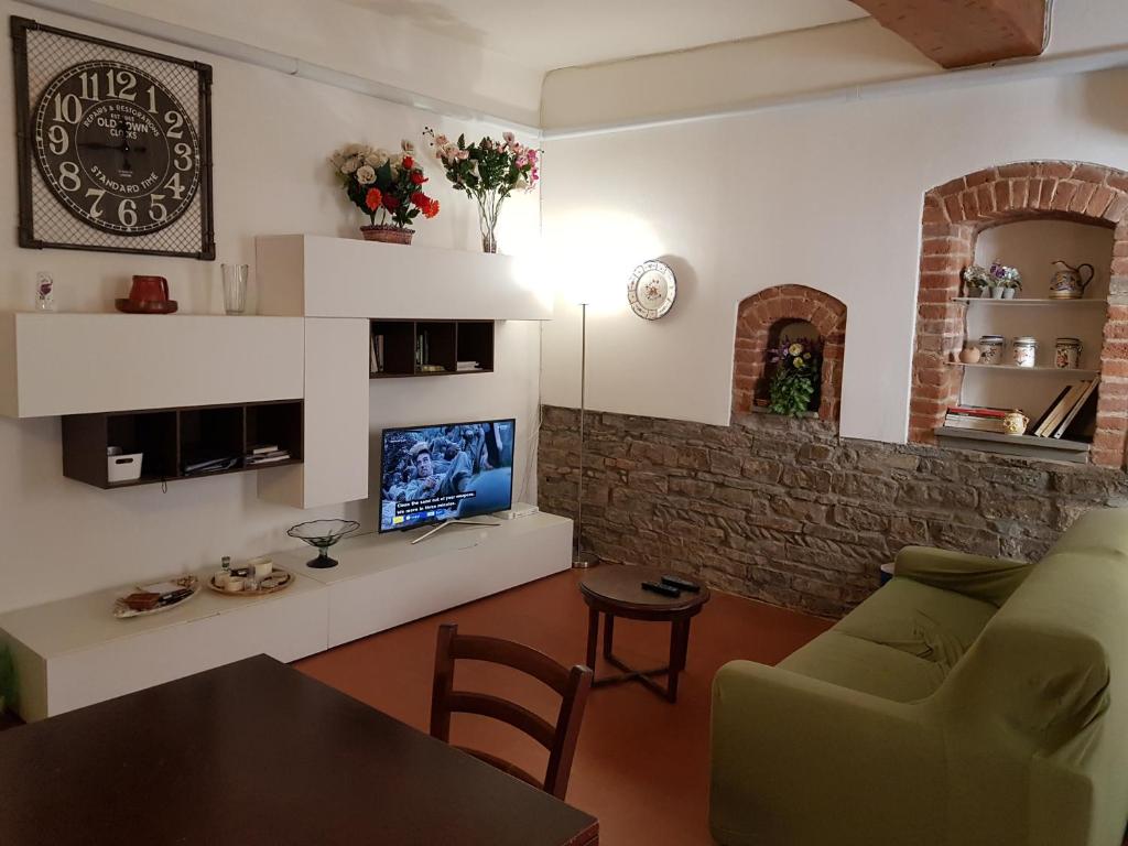 Una sala de estar con un sofá, una mesa y un televisor. en Appartamento del Campuccio, en Florencia