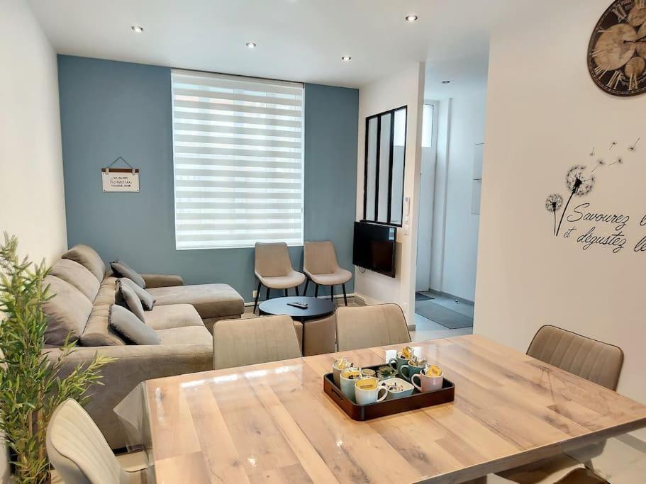 ein Wohnzimmer mit Sofa und Tisch in der Unterkunft Maison proche centre ville clim jardin wifi 8 personnes in Amiens