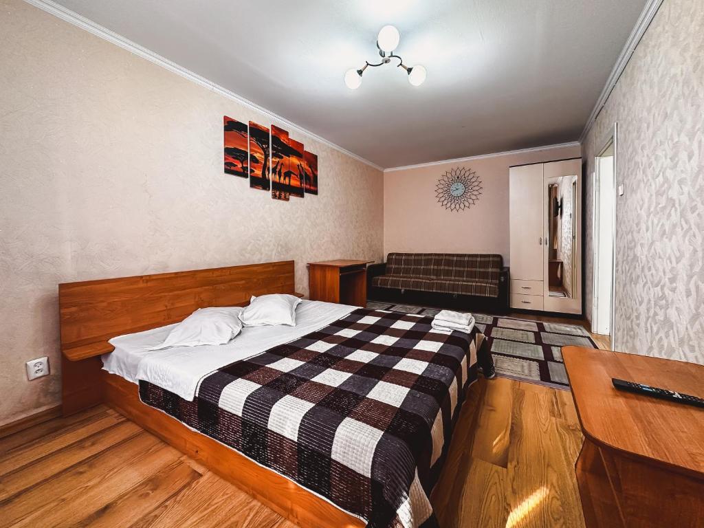 1 dormitorio con cama y escritorio. en Тасс уютная квартира в центре города, en Petropavlovsk