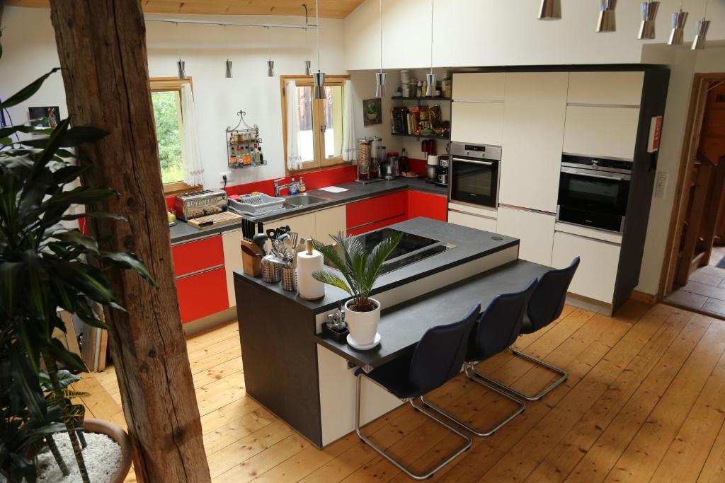 a kitchen with red cabinets and a island with chairs at CHALET ELISTHUR in Saint-Jean-d&#39;Aulps