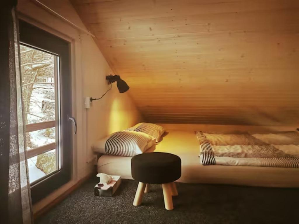 a bedroom with two beds in a wooden cabin at Chalupa přehrada Fojtka in Mníšek