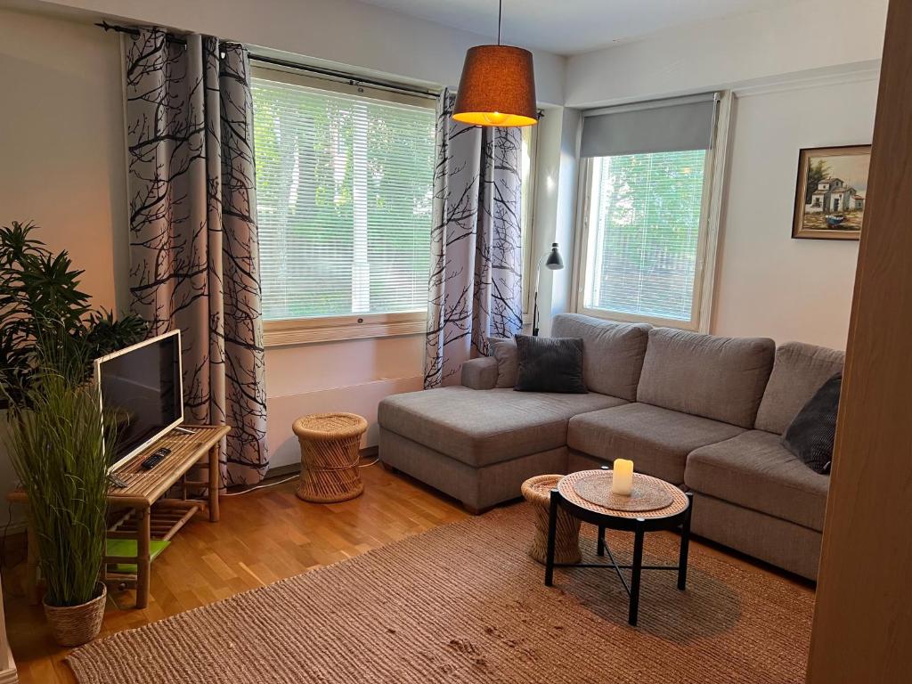 a living room with a couch and a tv at Cityflat Saimaa in Lappeenranta