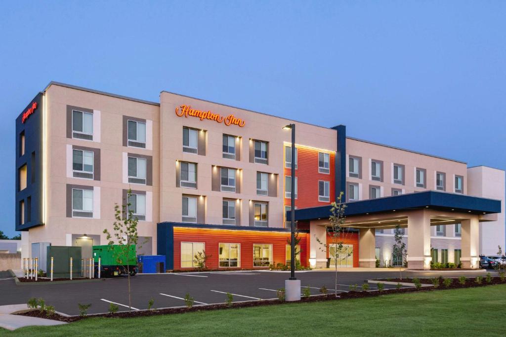 un edificio de hotel con un cartel en la parte delantera en Hampton Inn Stockton, Ca, en Stockton