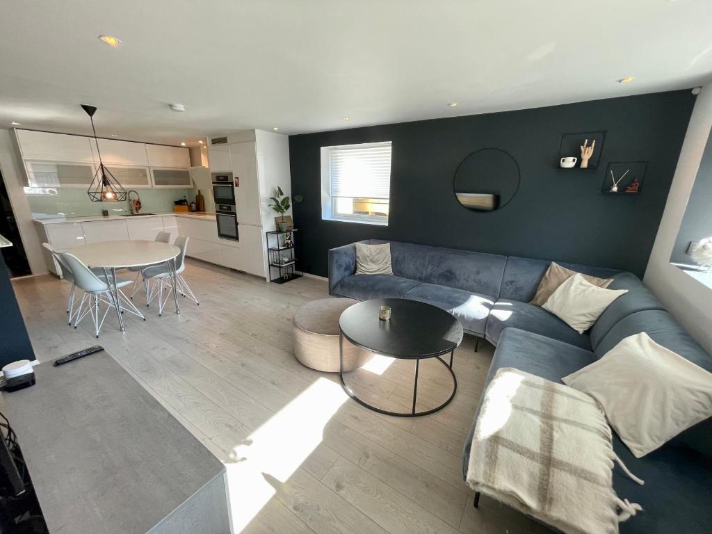 sala de estar con sofá azul y mesa en Luxury apartement close to city centre with free parking, en Tromsø